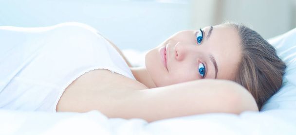 Красива молода жінка лежить в ліжку комфортно і блаженно
 - Фото, зображення