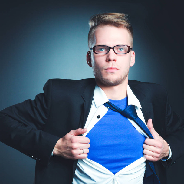Young businessman acting like a super hero and tearing his shirt, isolated on gray background - Φωτογραφία, εικόνα