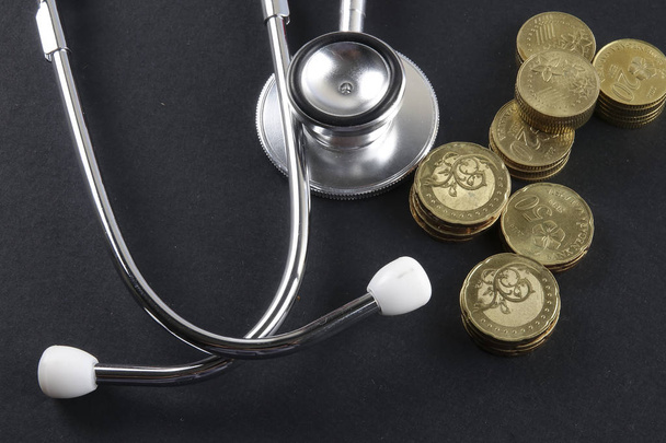 Red stethoscope,coin and puzzle on black. Medical concept. - Valokuva, kuva