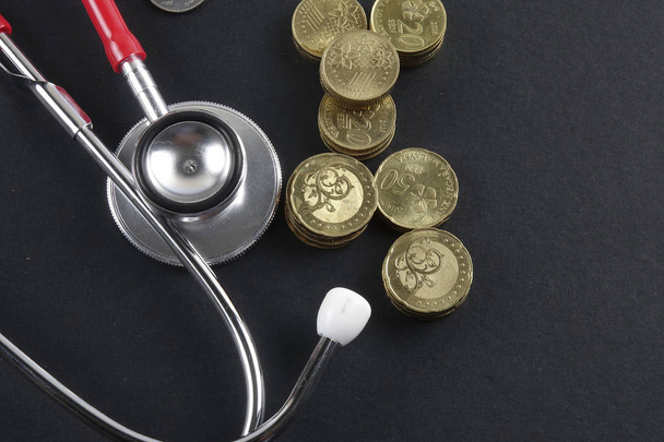 Red stethoscope,coin and puzzle on black. Medical concept. - Foto, afbeelding