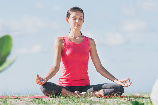 sporty giovane donna facendo meditazione all'aperto
 - Foto, immagini