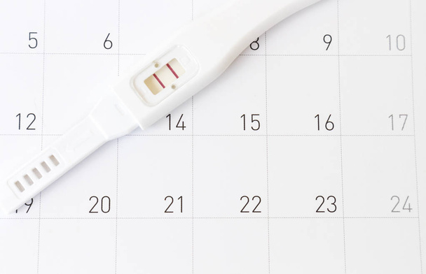 Těhotenský test na pozadí kalendáře, koncepce zdravotní péče - Fotografie, Obrázek