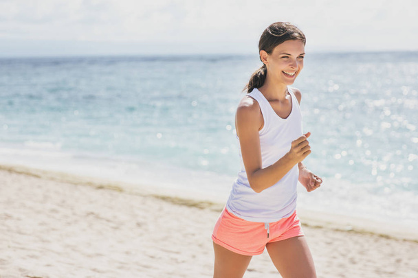 sporty woman jogging at the beach - 写真・画像