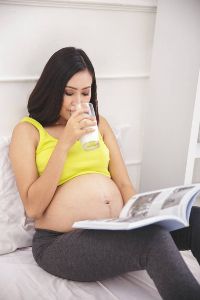  pregnant woman reading magazine - Фото, изображение
