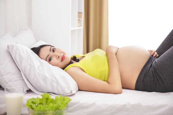 healthy pregnant woman lying on bed - Foto, imagen