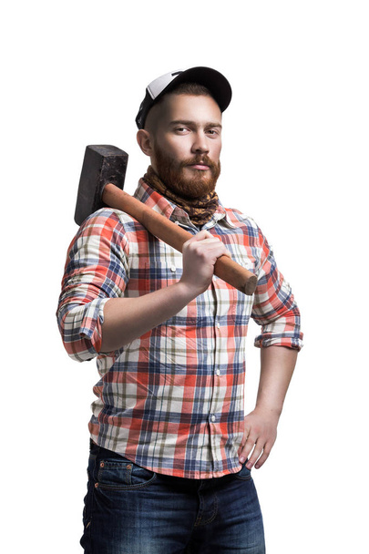 Bearded man wearing a cap hold hammer. - Foto, imagen