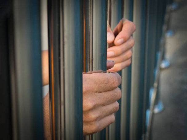 Hand of prisoner holding prison bars in jail. - Photo, Image