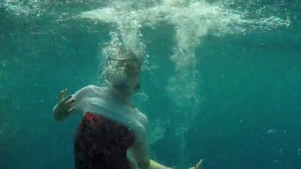 das Mädchen taucht unter Wasser und macht die Geste des "Namaste" in Zeitlupe - Filmmaterial, Video