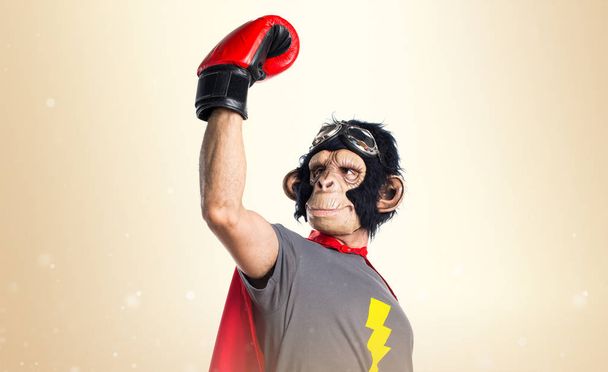 Hombre mono superhéroe suerte con guantes de boxeo en ocre backgroun
 - Foto, imagen