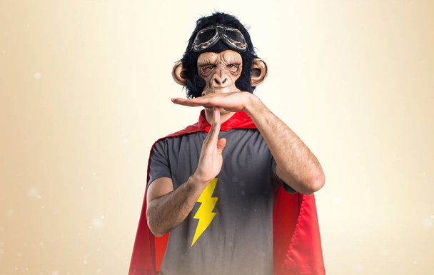 Supersankari apina mies tekee aikalisä ele okra tausta
 - Valokuva, kuva