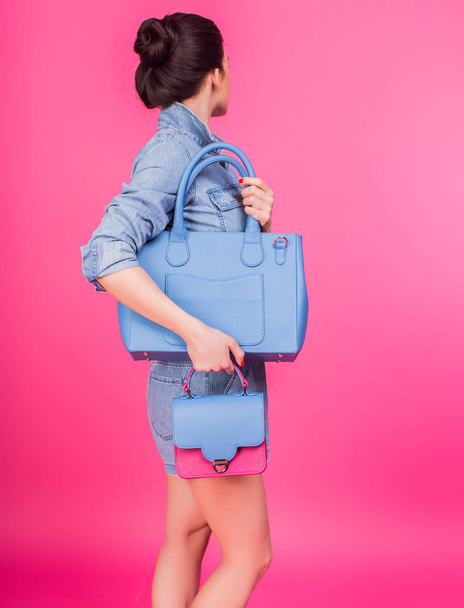 Mujer joven en denim sosteniendo bolso azul
 - Foto, imagen