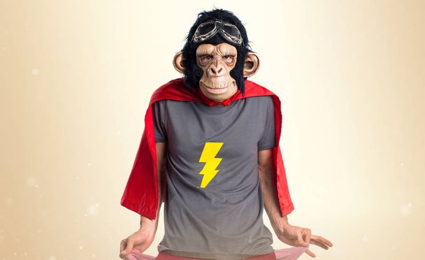Zničil opičí muž hledá peníze v jejich kapsách na okrové pozadí - Fotografie, Obrázek