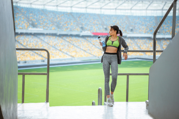 Sportvrouw op leuning op stadion  - Foto, afbeelding