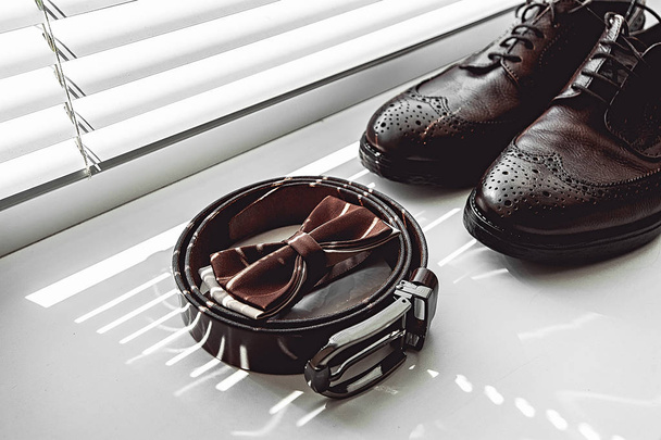 Brown bow tie, leather shoes and belt. Grooms wedding morning. Close up of modern man accessories - Foto, immagini