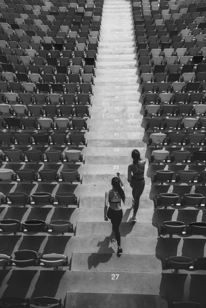 sportswomen running on stadium stairs - Photo, Image