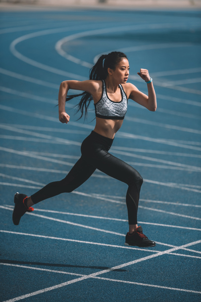 Sportlerin trainiert auf Laufstrecke - Foto, Bild