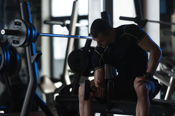 Exercício de bíceps com halteres em um ginásio
 - Foto, Imagem
