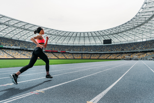 Sportswoman running on stadium  - Foto, Bild