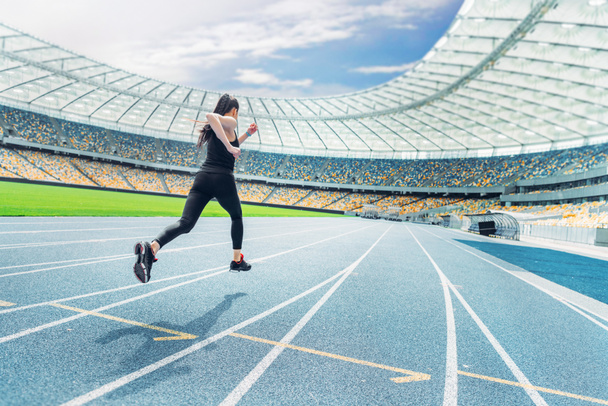 Sportswoman running on stadium  - Foto, immagini