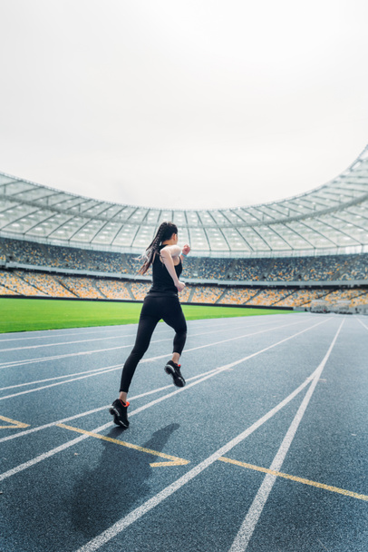 Sportswoman running on stadium  - Фото, зображення
