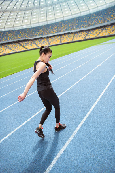 Sportswoman running on stadium  - Foto, afbeelding