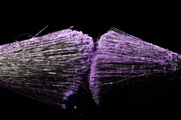 Макияж кисть с фиолетовой пыли на черном фоне
 - Фото, изображение