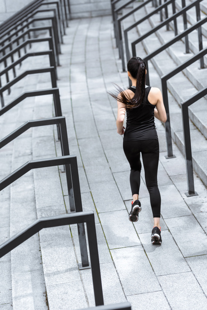 Sportswoman training on stadium stairs  - Foto, imagen