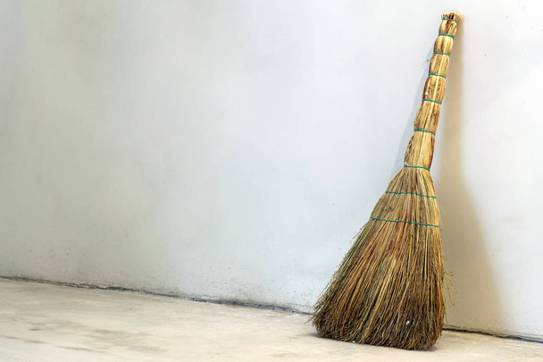 Old obsolete broom or besom leaning on the gray wall - Photo, Image