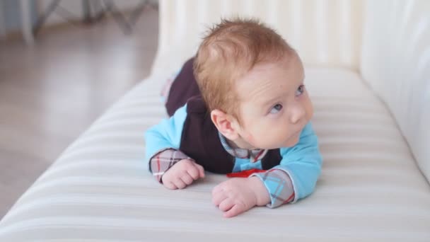 Cute baby lying on the white bed - Séquence, vidéo