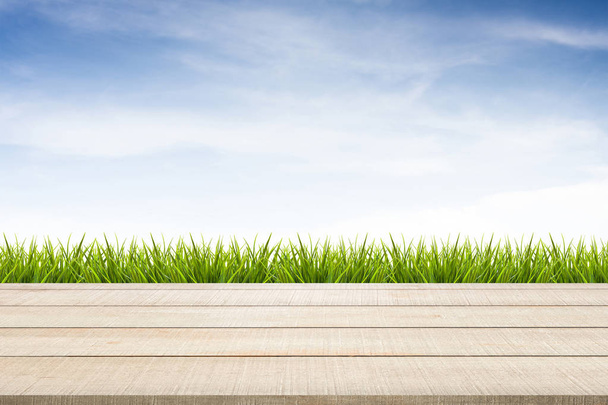 houten tafel bovenste paneel, gras en hemel achtergrond - Foto, afbeelding