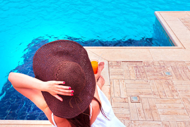 Жінка насолоджується коктейлем у басейні
 - Фото, зображення
