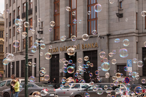 Prague, Cseh Köztársaság - 2017. április 21.: az épület a Cseh Nemzeti Bank, színes buborékok lebeg - Fotó, kép