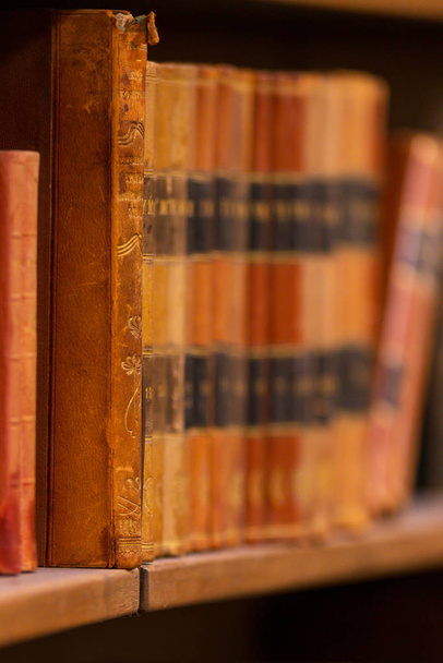 Vintage books on the shelfs with shallow depth of field at the r - Fotografie, Obrázek