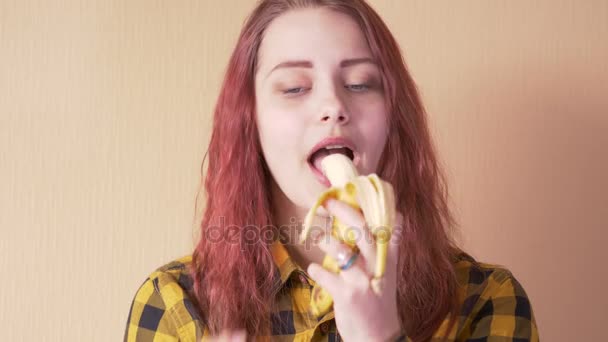 Roztomilý dospívající dívka jíst banán - Záběry, video