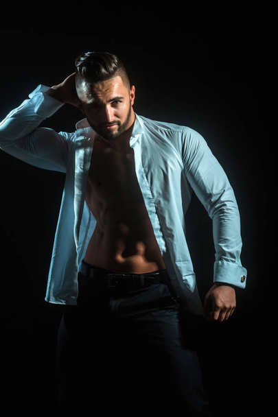 Sexy businessman on black background. Seductive and attracting man. Brunette man in white unbuttoned shirt - Photo, Image
