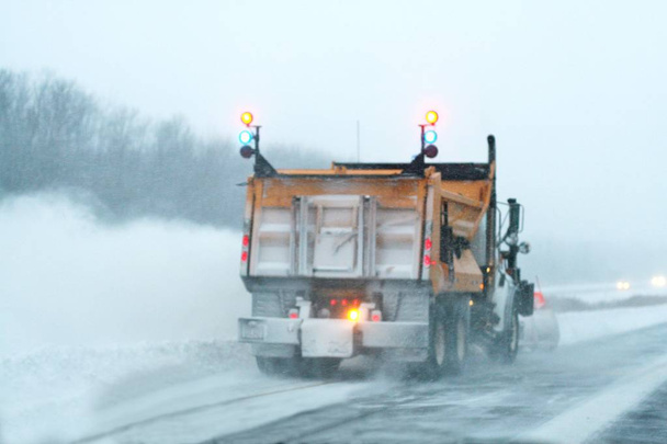 Vrachtwagen ploegen in een sneeuwstorm - Foto, afbeelding