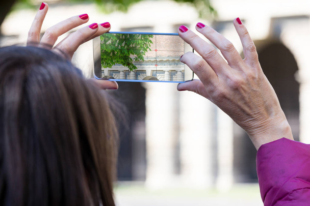 市では、透明な携帯電話で写真を撮る女性 - 写真・画像