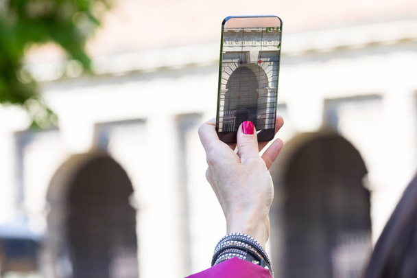 жінка в місті робить фотографії з прозорим телефоном
 - Фото, зображення