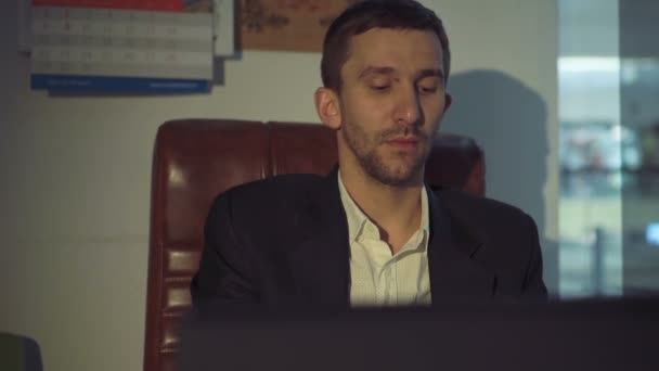 Tired businessman speaking on the mobile phone in the office 4K - Felvétel, videó