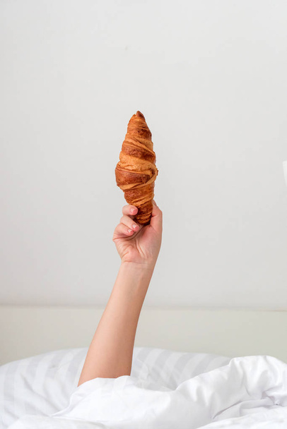 woman hand holding croissant - Φωτογραφία, εικόνα