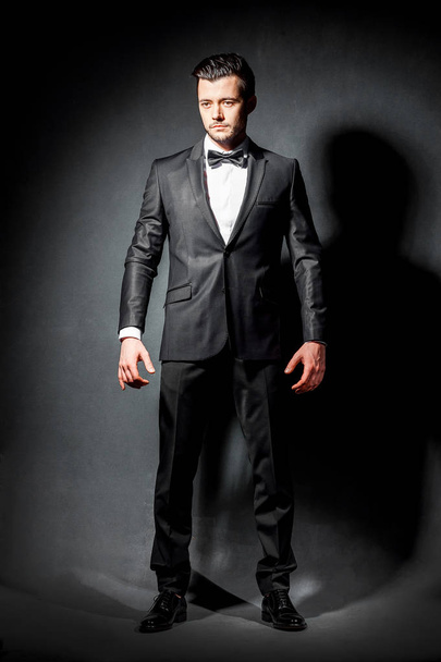 portrait of confident handsome man in black suit with bowtie - Photo, Image