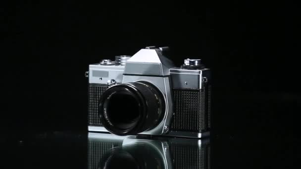 Analog photo camera rotating on reflective surface. - Footage, Video