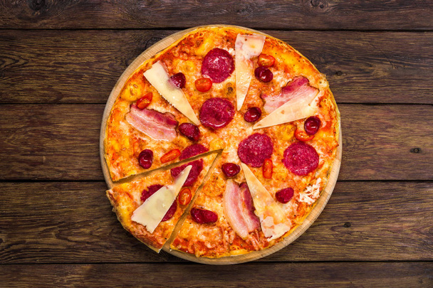 Delicious italian pizza with salami, bacon and parmesan - Photo, Image