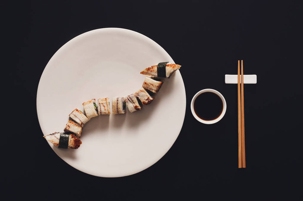 Zestaw unagi sushi i bułki na czarnym tle, widok z góry - Zdjęcie, obraz