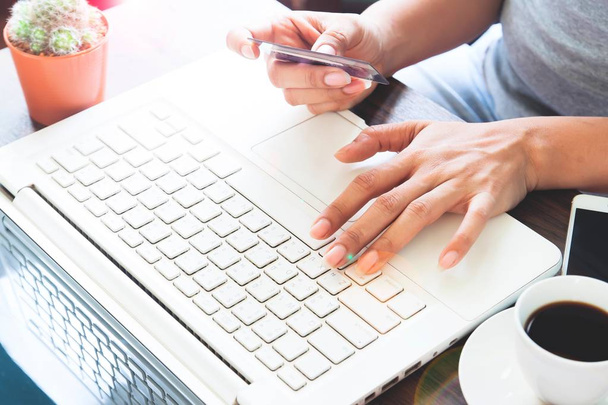 Жінка в повсякденному одязі, використовуючи ноутбук з кредитною карткою, інтернет-покупки вдома
 - Фото, зображення
