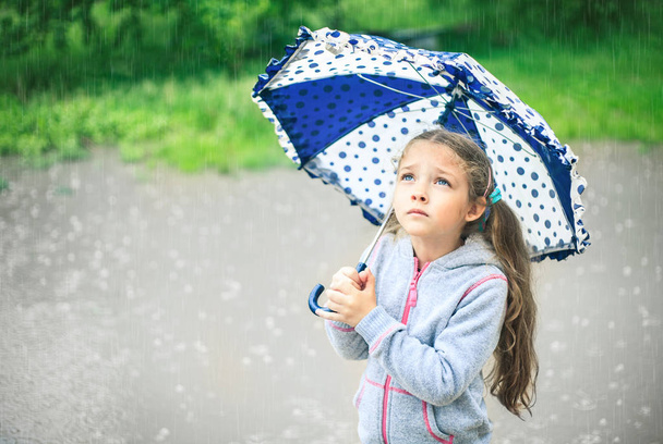 傘を持つかわいい悲しい少女の肖像画. - 写真・画像