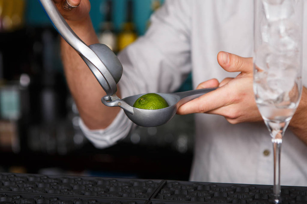 Barmans hands making cocktail with lime - Photo, Image
