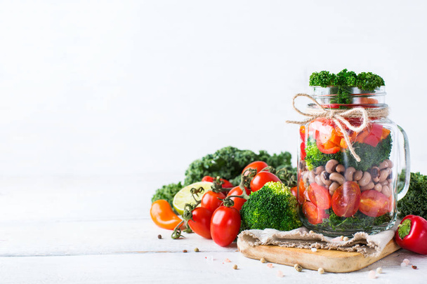 Salada vegan saudável em um frasco de pedreiro com feijão
 - Foto, Imagem