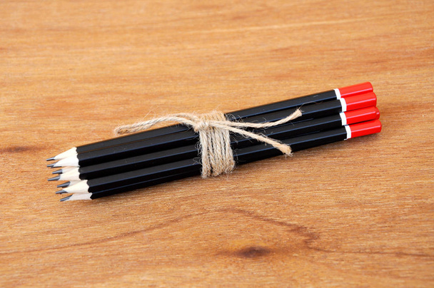 Black pencils tied with a rope of straw yarn.  - Fotoğraf, Görsel
