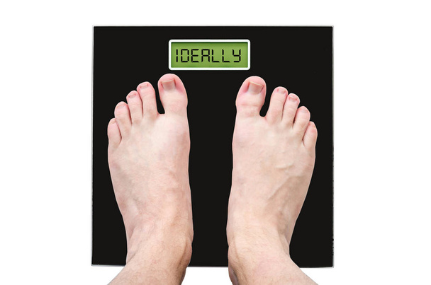 Мужчина на весах с нормальным весом и хорошим здоровьем, надпись - в идеале
 - Фото, изображение